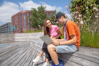twee studenten zitten op het dakterras van de VU