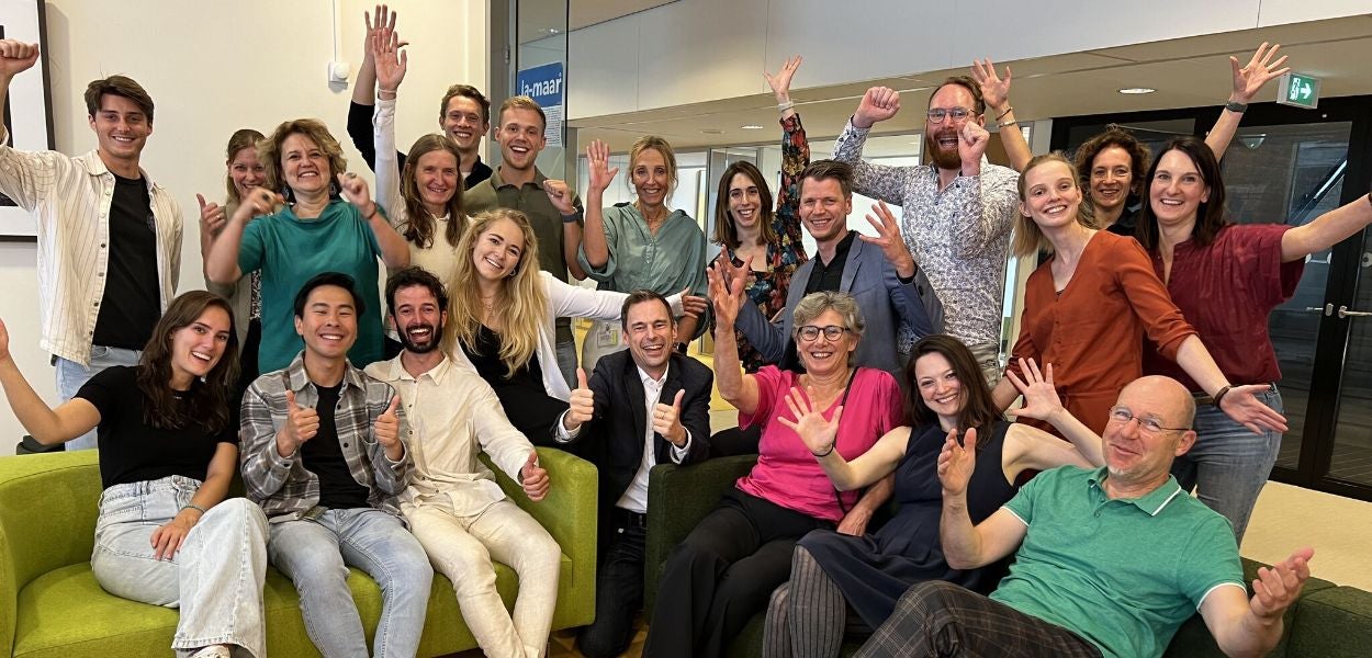 The winners of the education awards and their mentors celebrate the achievement together, while cheering and posing in a room.