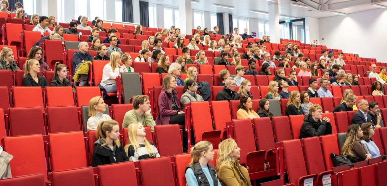 A lecture hall filled with students who are listening attentively.