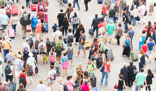  toeristen die met koffers lopen