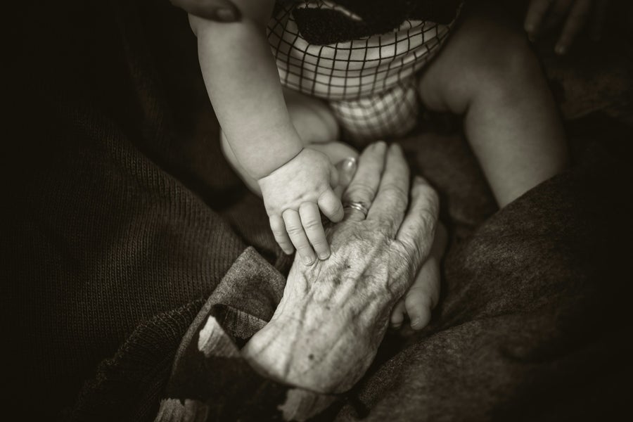 two hands, young and old, holding each other