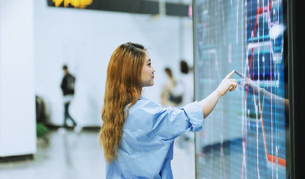 A student touches a large touch screen