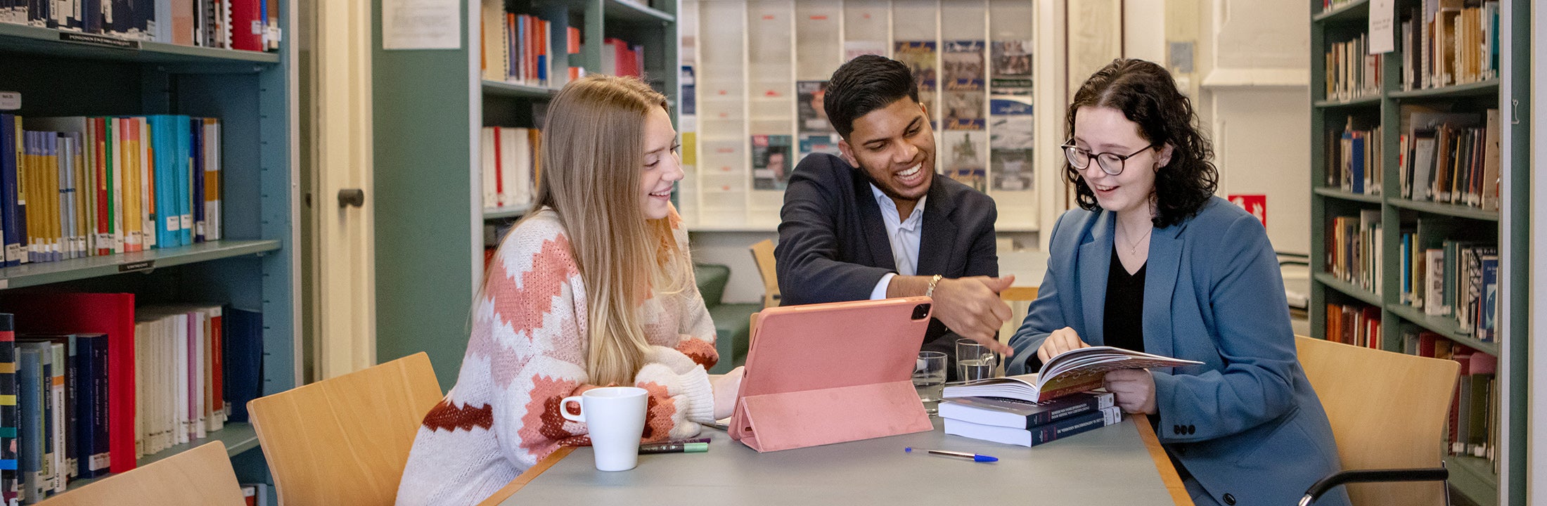 Drie studenten kijken in een boek