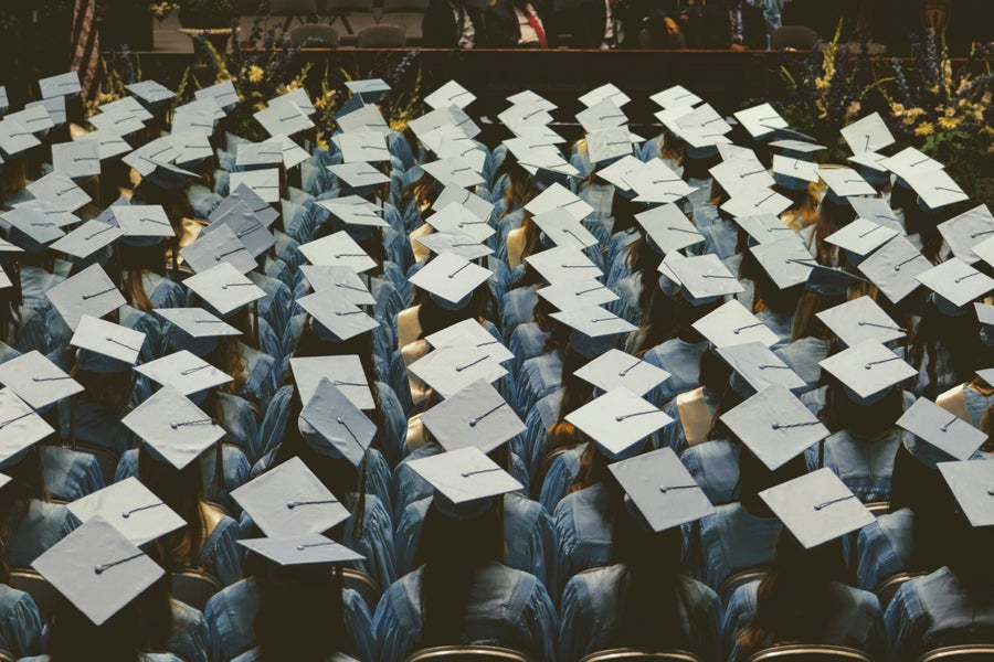 A group of graduates in graduation gowns and -berets are ready for their graduation ceremony. 