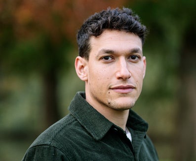 A man with short dark hair and a green shirt