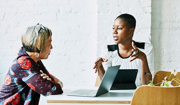 Twee vrouwen in gesprek in een kantoorsetting