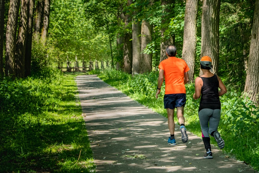 Twee mensen rennen door een bos