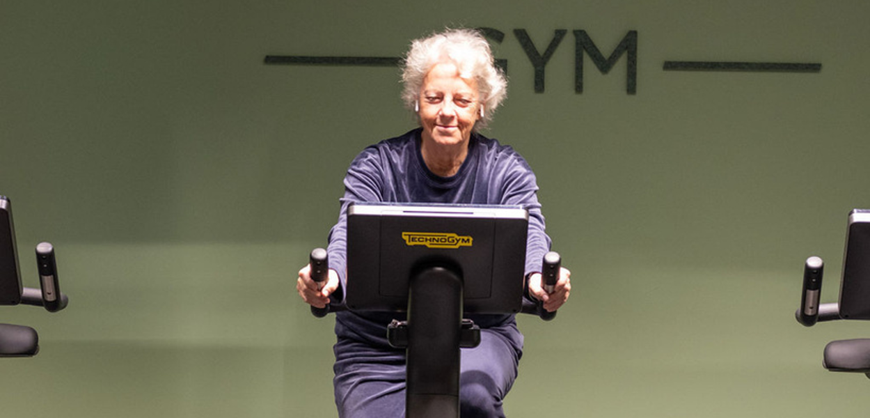 Older woman on a fitness bike indoor