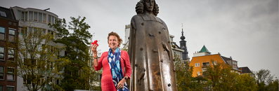 Yvette van Kooyk bij het standbeeld van Spinoza in Amsterdam