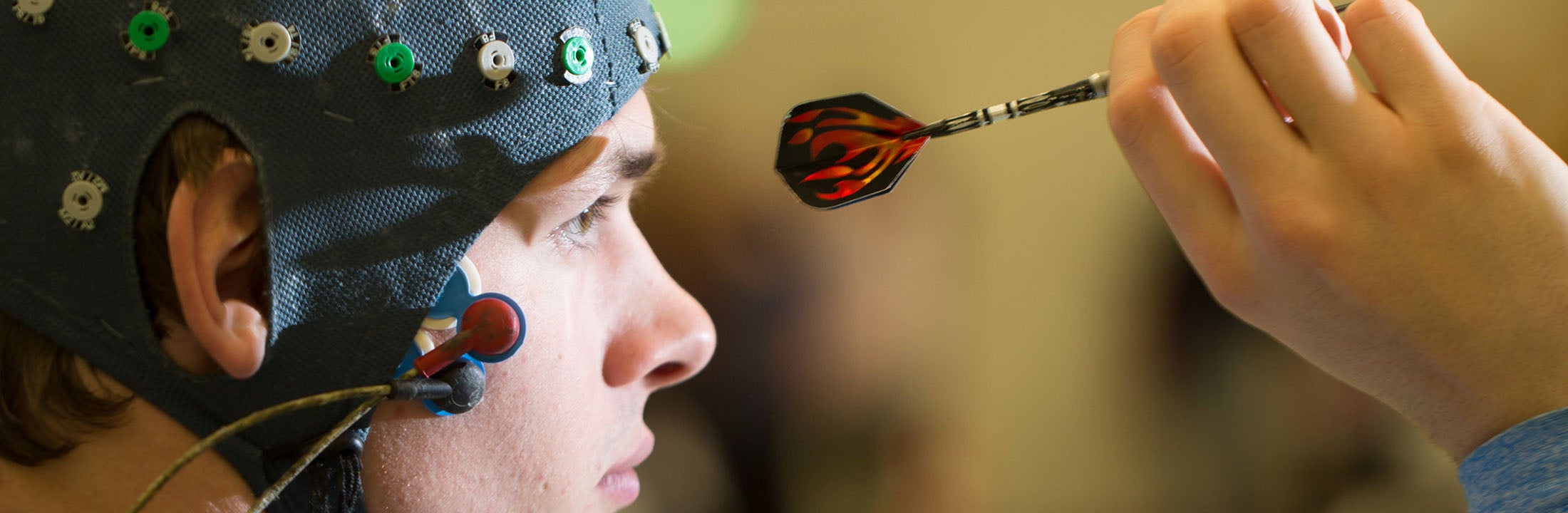 Man playing darts while participating in a scientific brain research