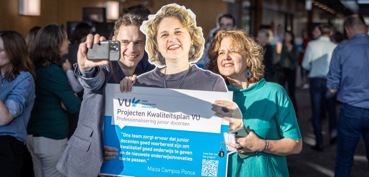 Jeroen Geurts en Maiza Campos Ponce maken een selfie bij de levensgrote cut-out van Maiza, waarop de titel van haar project en de QR-code naar haar interview staan