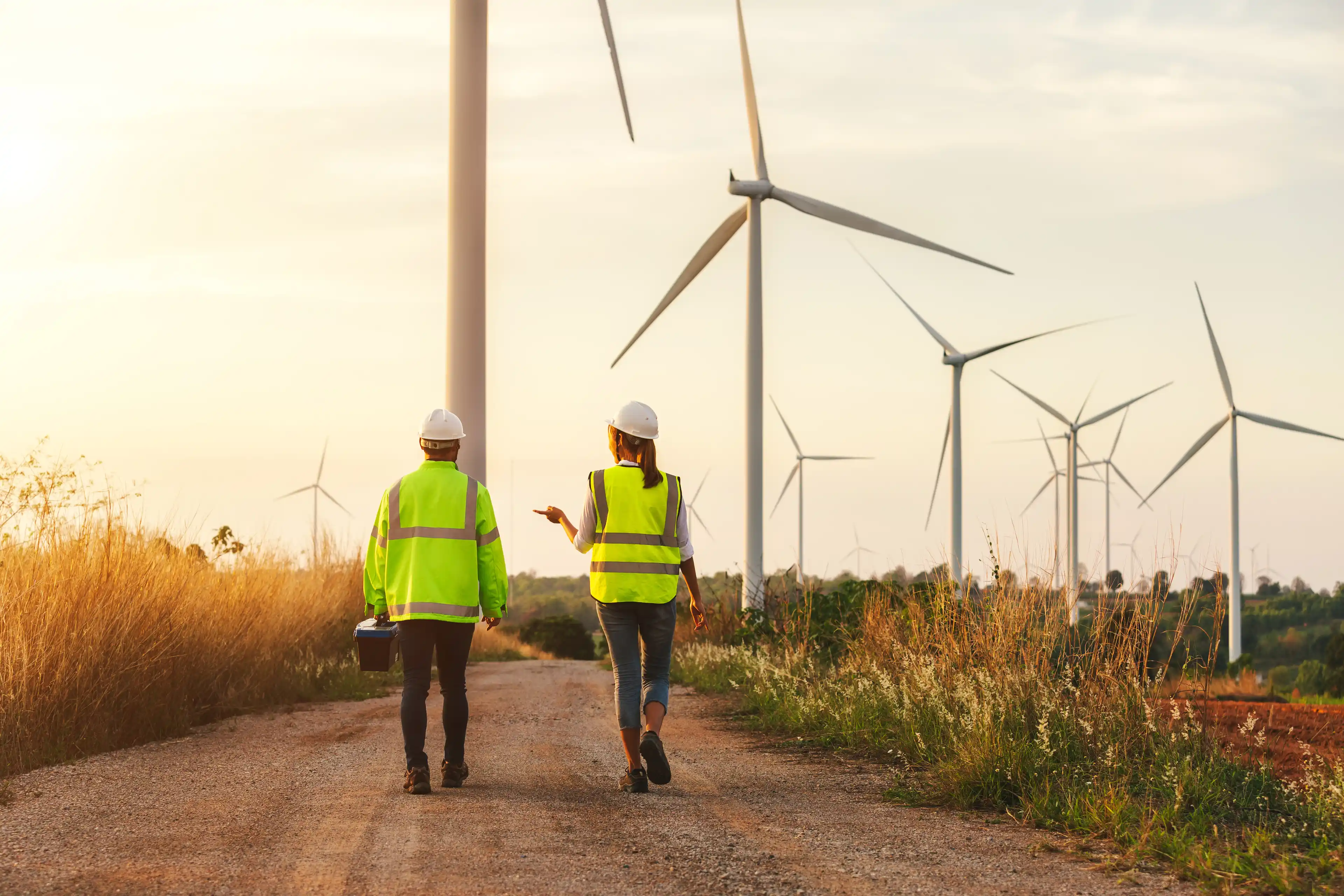Two engineers walking through a Wind Farm