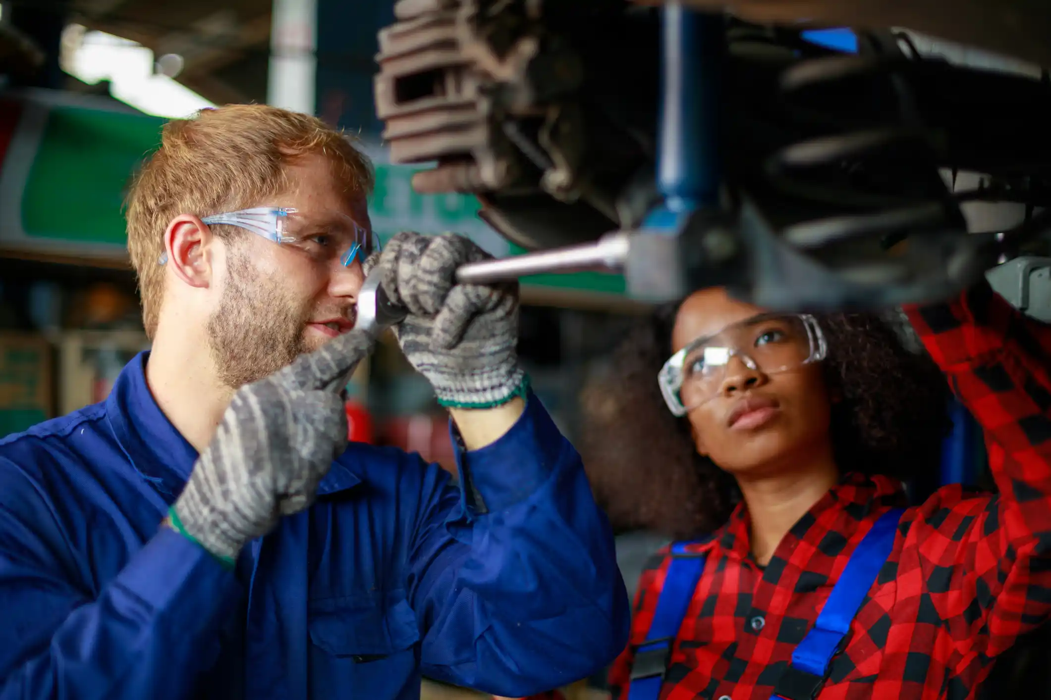 Two mechanics at work. Two confident auto mechanic working at the repair shop
