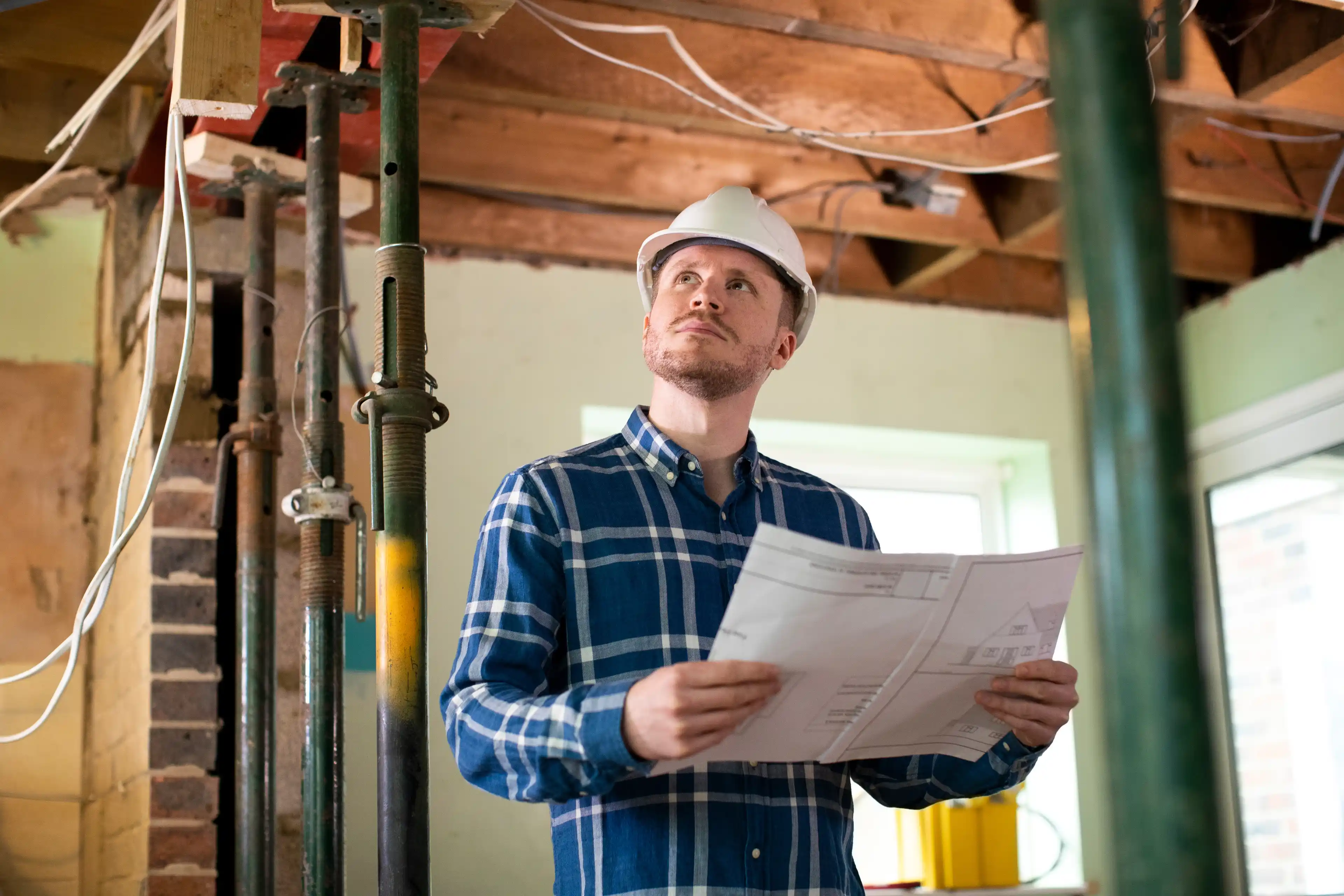 Architect Inside House Being Renovated Studying Plans