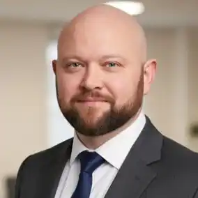 image of Ky James Marland, a white male wearing a black suit with black tie