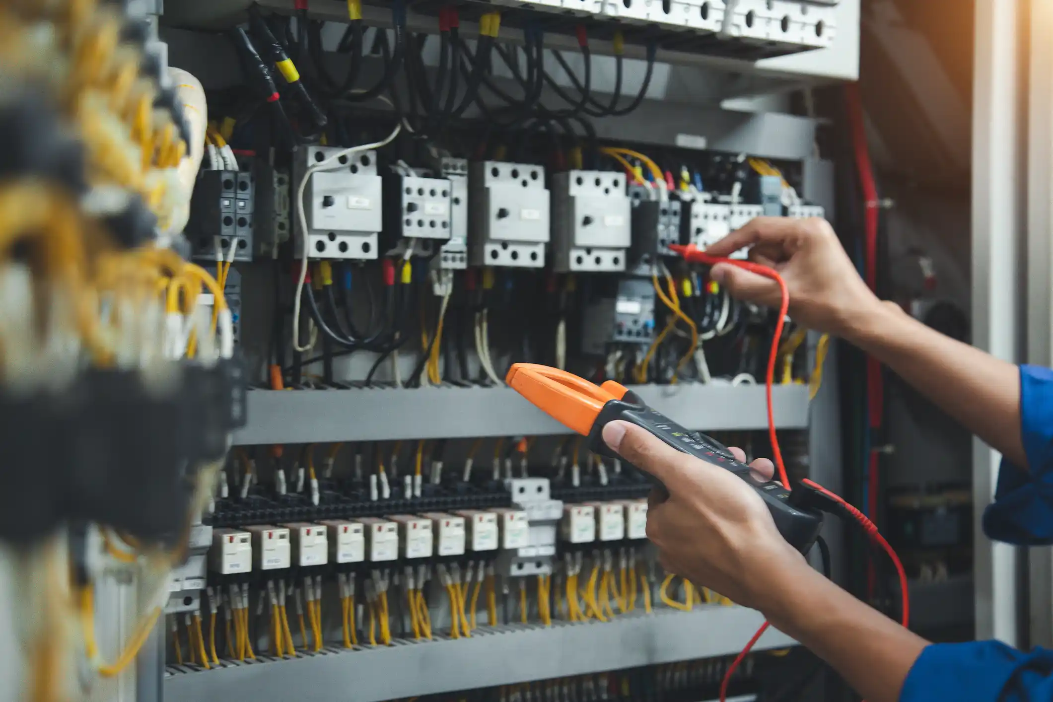 Electrician measurements with multimeter testing current electric in control panel, safety concept