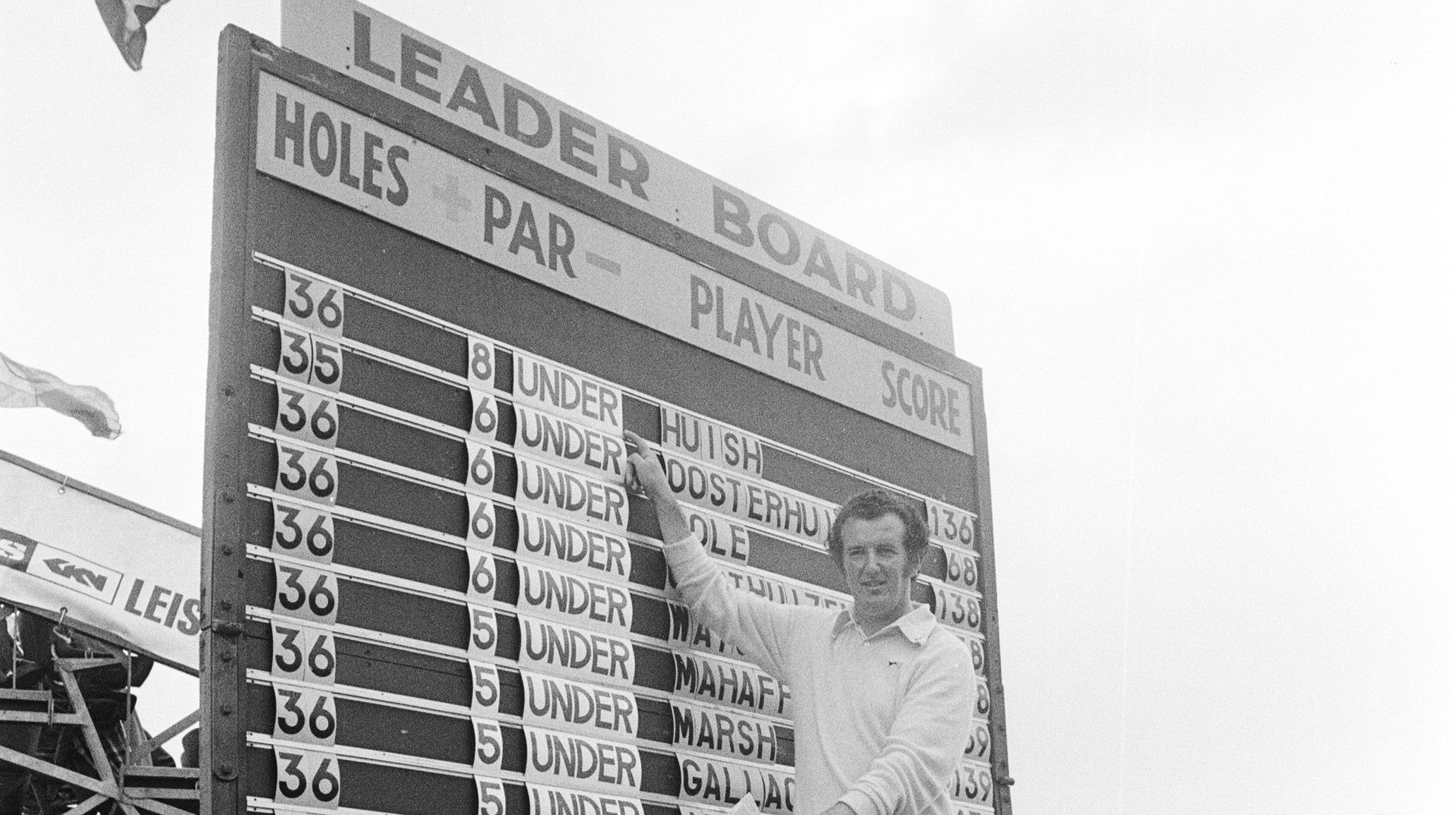 David Huish pointing at a leaderboard with his name on top