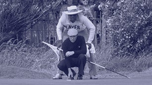 Gary Player lines up a putt with his caddie Alfred 
