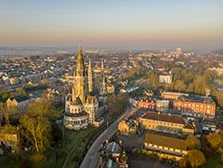 Aerial sunrise view of Cork City centre, featuring the landmark building St Fin Barre’s Cathedral.