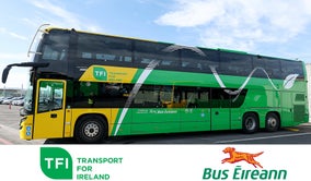 A green and yellow Bus Éireann/TFI bus is parked. It is a sunny day