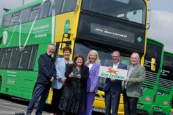 Bus Éireann's Chair, CEO and Chief People manager met with members of IBEC in front of a green and yellow bus to receive the IBEC keepwell mark