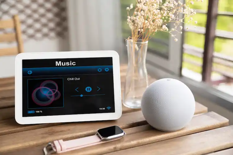 En la fotografía, distintos dispositivos en los que se puede acceder a asistentes de voz, tales como: smartwatch, tablet y reproductor para el hogar tipo Google Home.