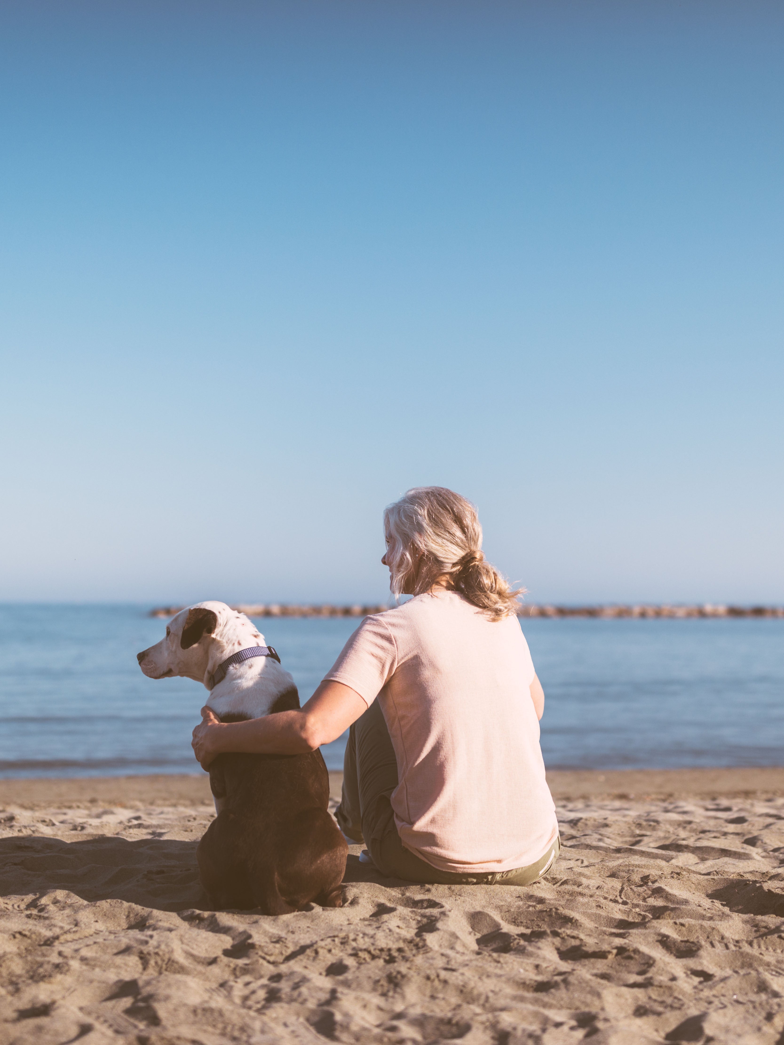 Image of woman with dog on the beach