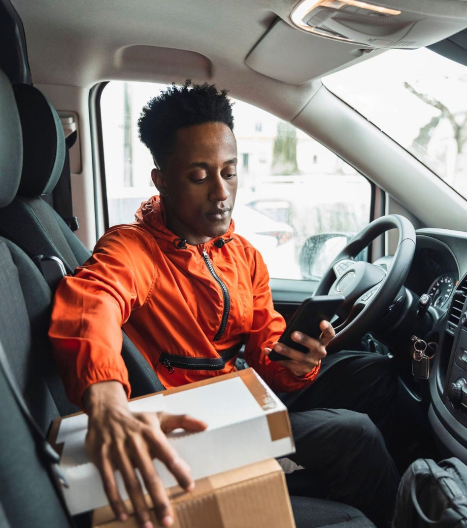 Delivery driver checking his phone on delivery