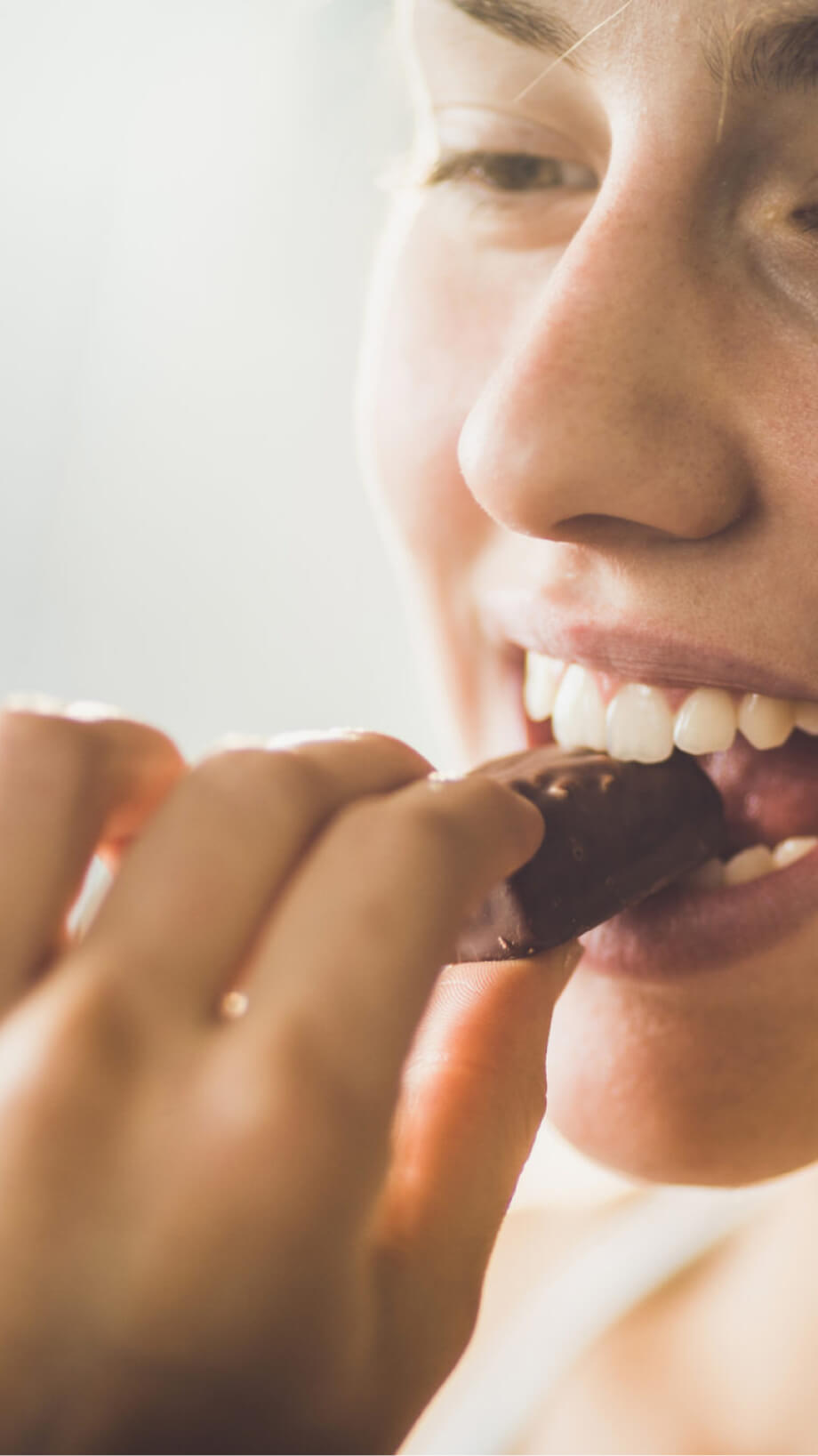 A young woman eats some chocolate