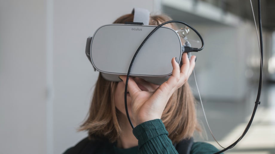 An individual is balancing the virtual reality headset with their hand.