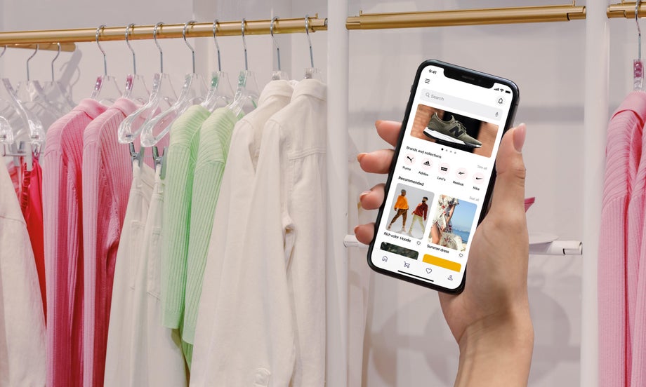 A person shops in store while also browsing on a fashion App