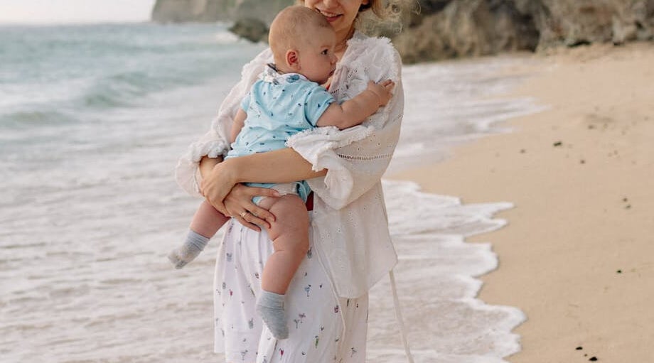 Woman with a baby on a sunny beach, representing Irish Life Health's customer-first approach