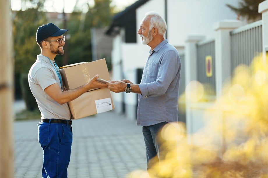 Courier giving a touchpad to a senior customer