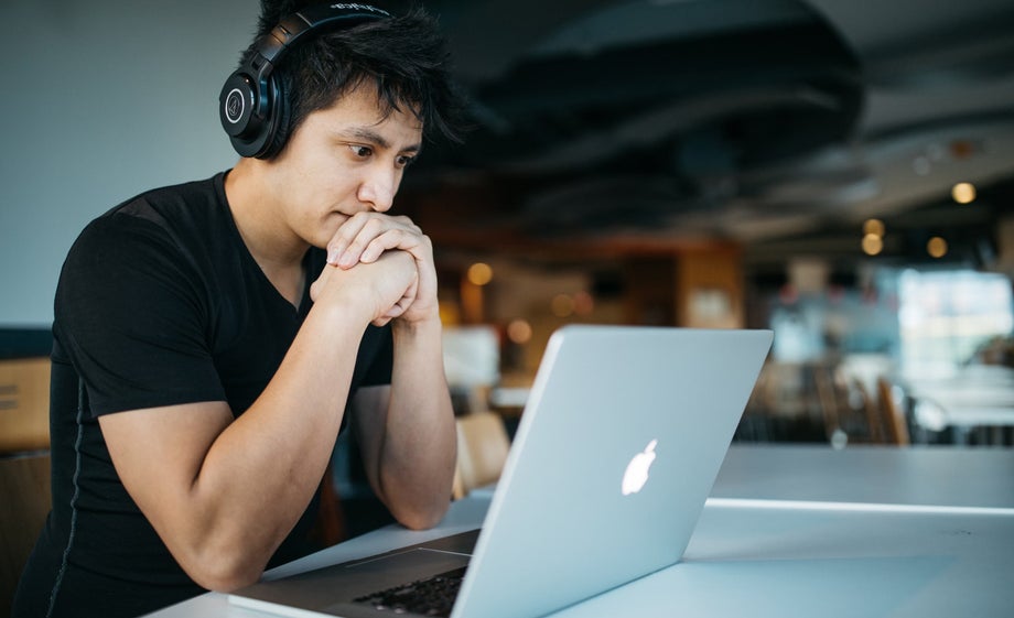 A person focuses on their laptop screen 