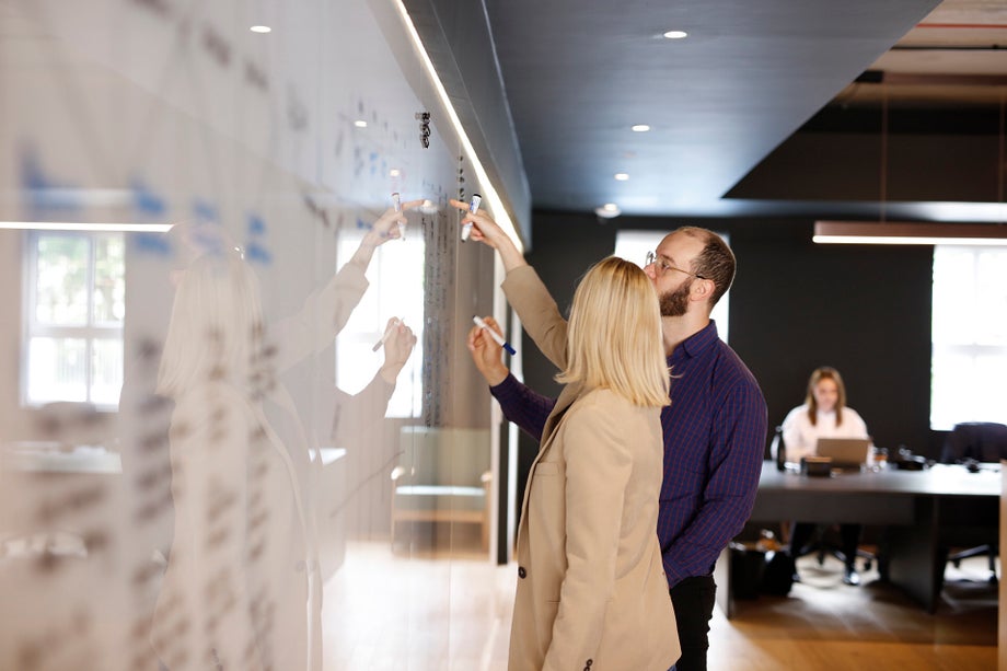 Two people planning on a whiteboard