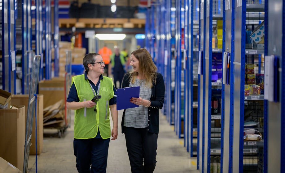 Coworkers chat while walking through product aisles