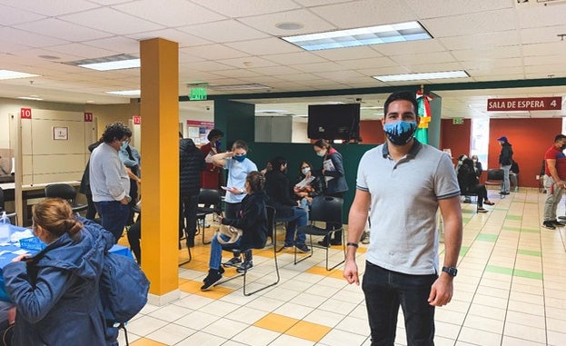 Garcia stands inside a COVID-19 vaccination facility, where he and his wife help Georgians complete paperwork and answer any questions while they wait to get vaccinated.