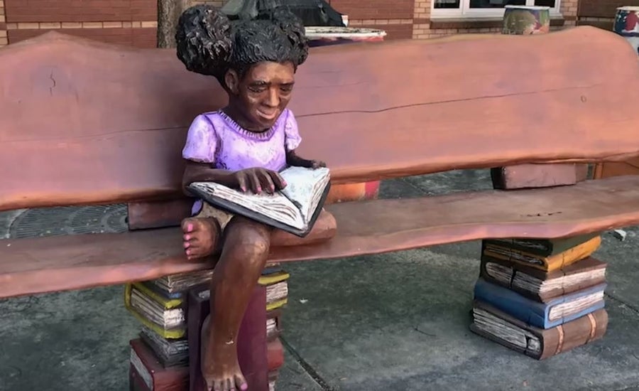 Wooden sculpture, “Girl reading on a bench” at M. Agnes Jones Elementary School in Atlanta, Ga.