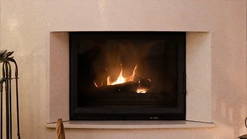 A concrete fireplace with a fire burning