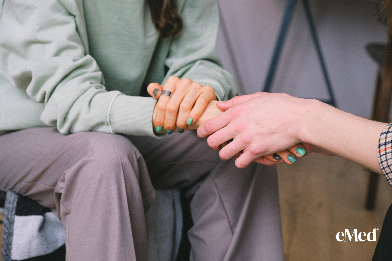 A person holding hands with another person needed mental health support. 