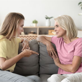two woman sitting on a sofa and talking