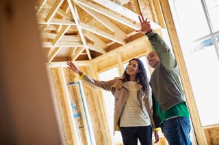 Couple looking at home being built