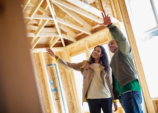 Couple looking at home being built