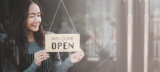 Business owner holds open sign
