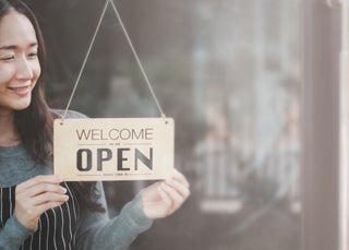 Business owner holds open sign