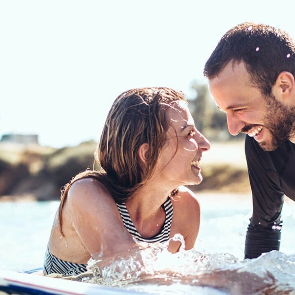 Two people surfing look at each other
