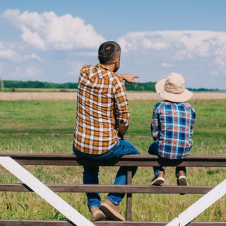 Father and son on fence at their farm