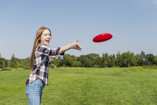 Girl throws frisbee to a friend