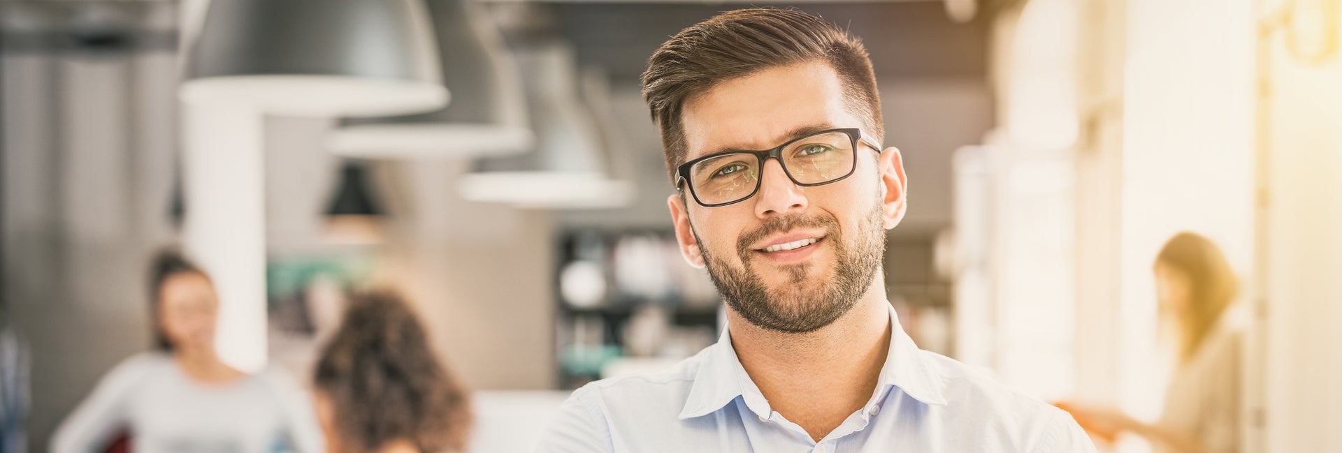 businessman smiles with coworkers in the background