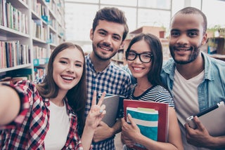 Group of students in pose for photo in library